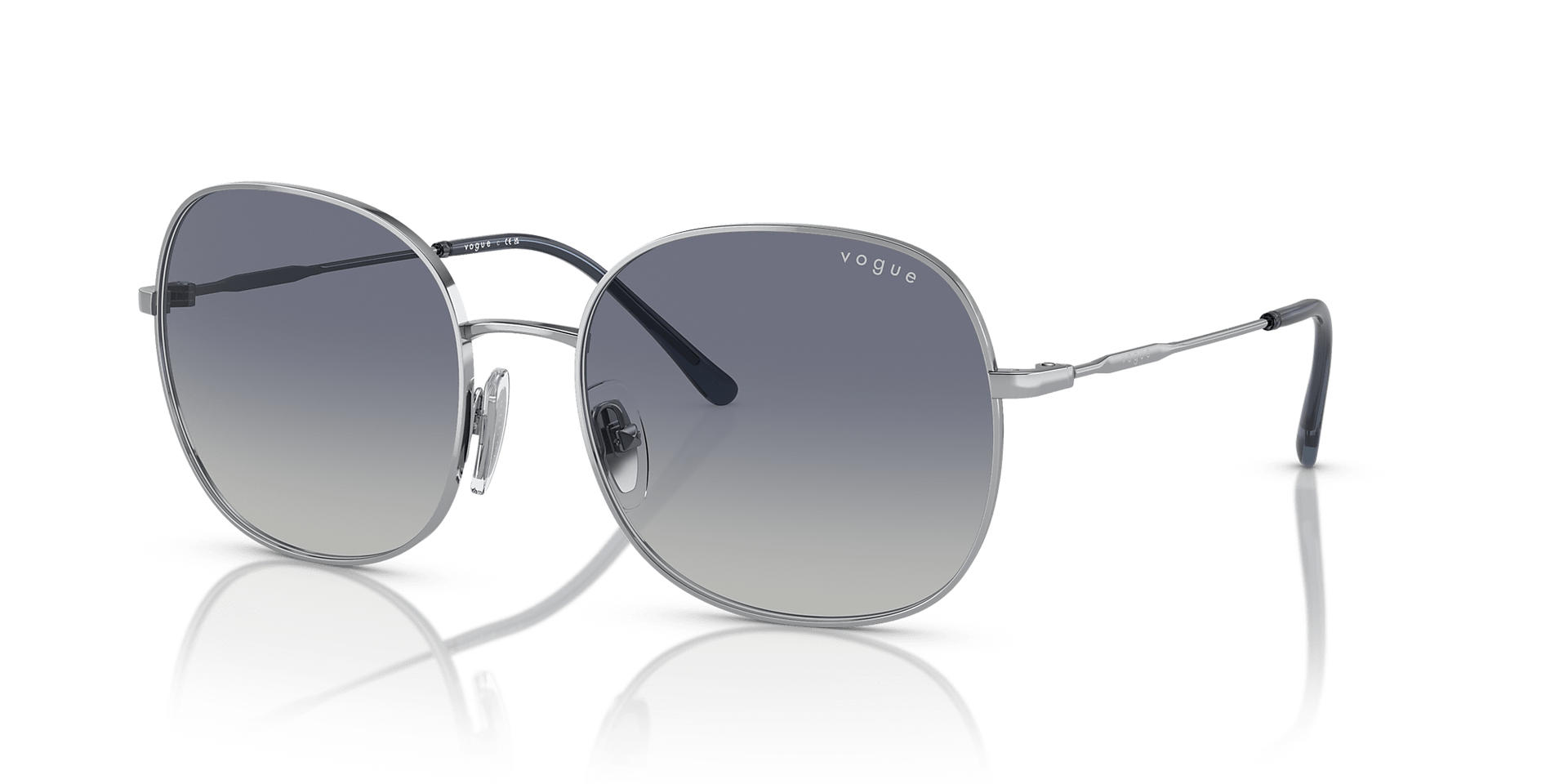 A pair of sunglasses on a white surface with a reflection.