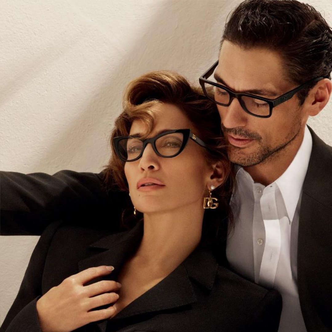 A man and a woman wearing glasses are posing for a picture