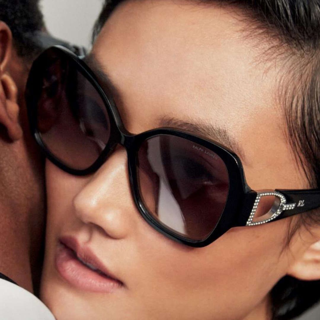 A close up of a woman wearing sunglasses with the letter d on it