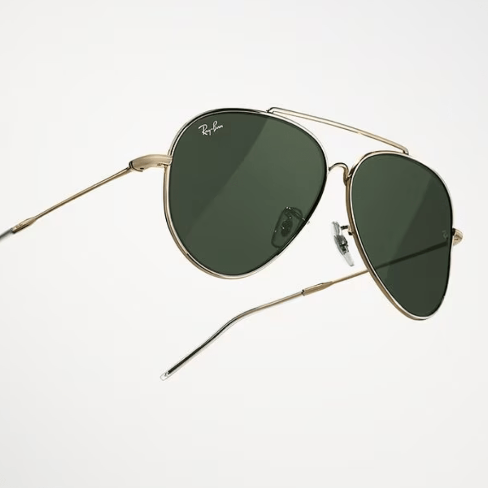A pair of ray-ban sunglasses with green lenses on a white background