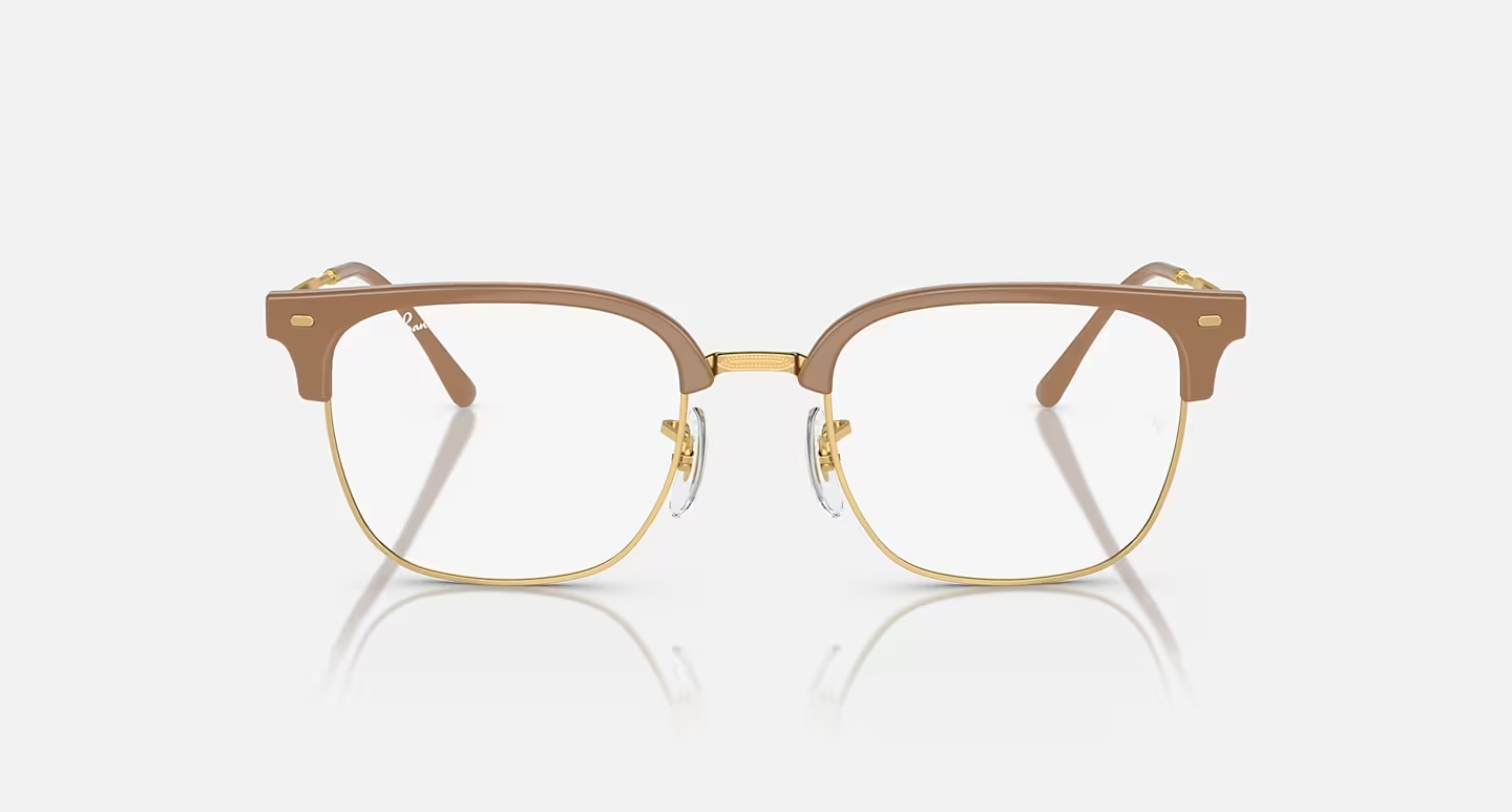 A pair of brown and gold glasses on a white surface.
