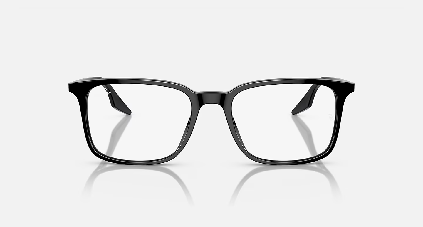 A pair of black glasses are sitting on a white surface.