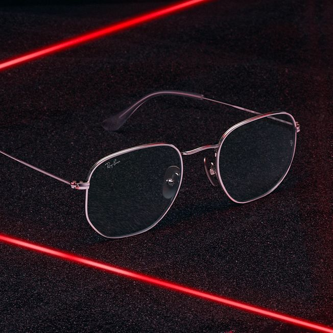 A pair of ray-ban sunglasses sitting on a black surface