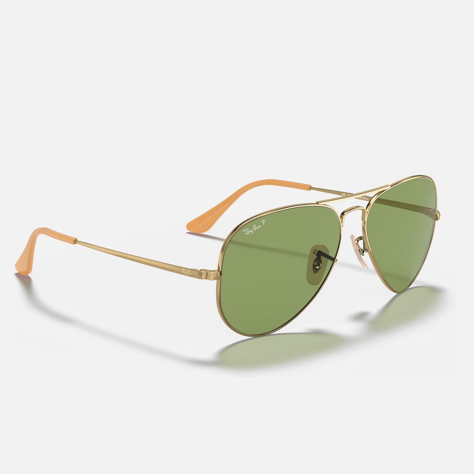 A pair of ray-ban aviator sunglasses with green lenses on a white background.