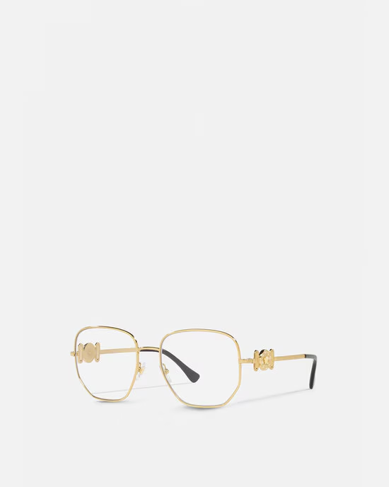 A pair of gold glasses with a clear lens on a white background.