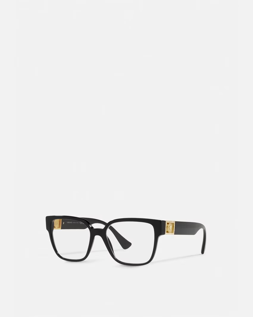 A pair of black glasses with gold trim on a white background.