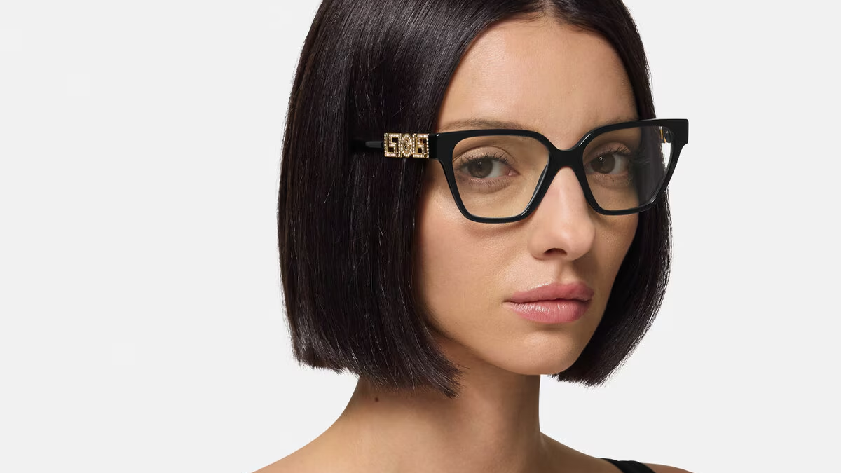 A close up of a woman wearing glasses on a white background.