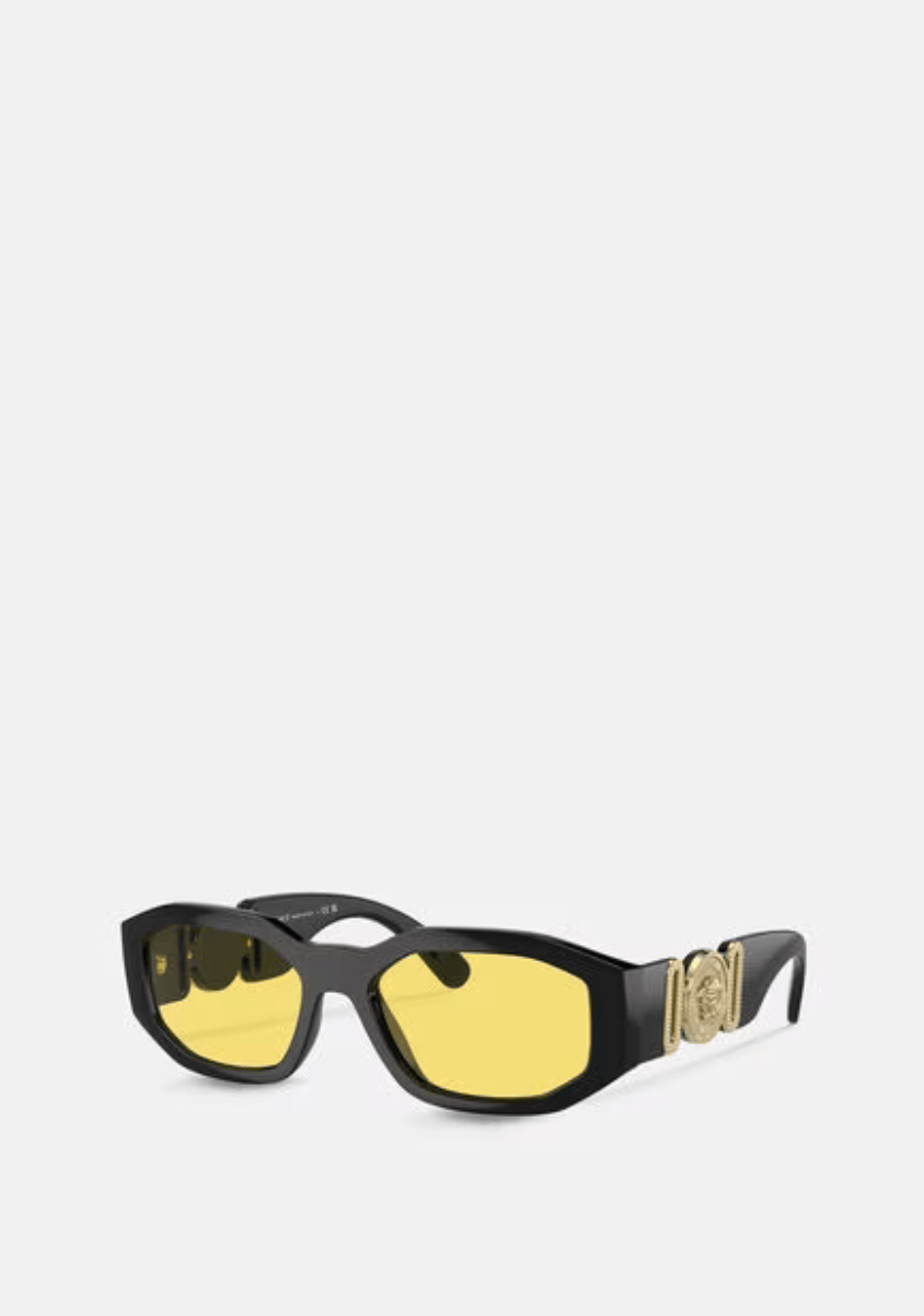 A pair of black sunglasses with yellow lenses on a white background.