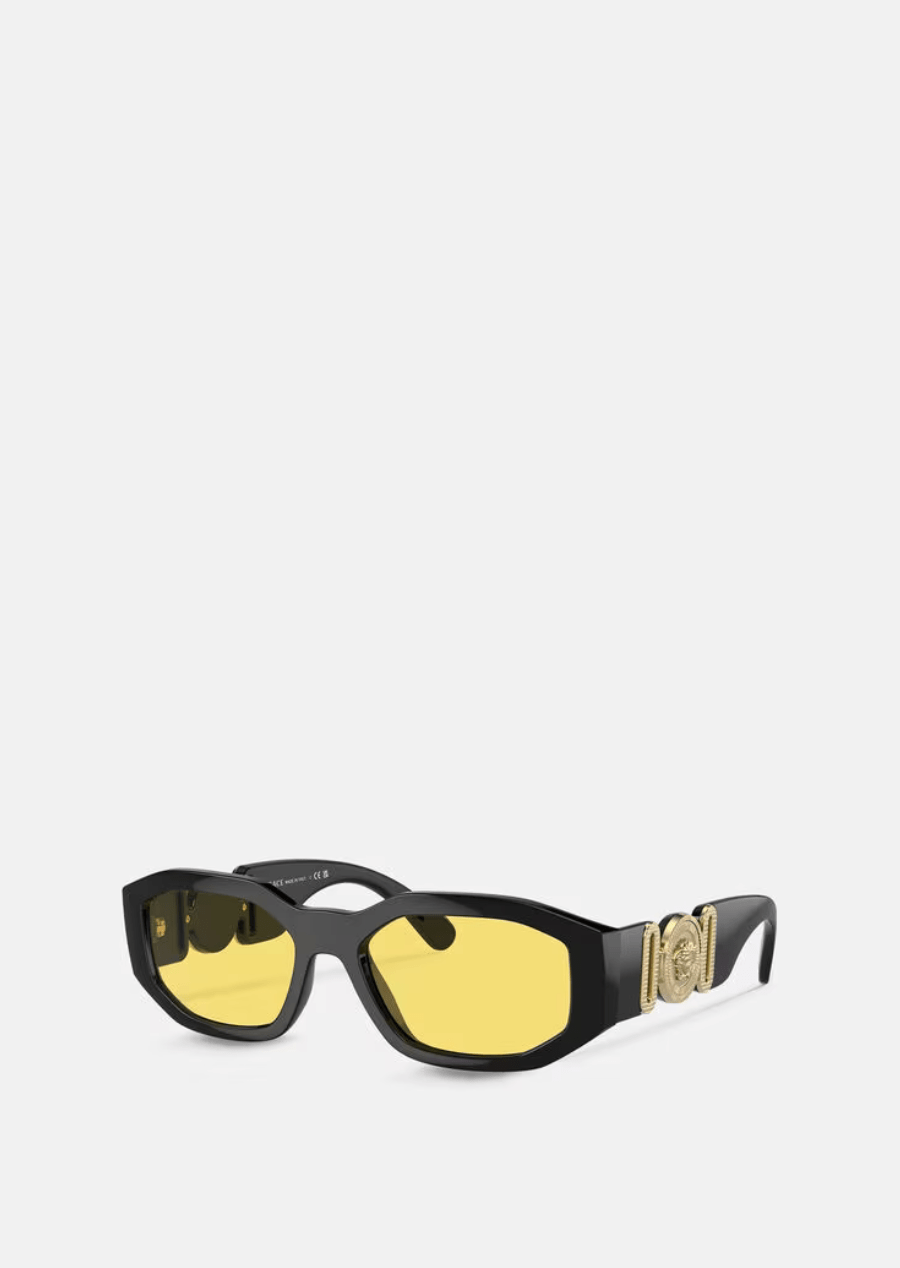 A pair of black sunglasses with yellow lenses on a white background.