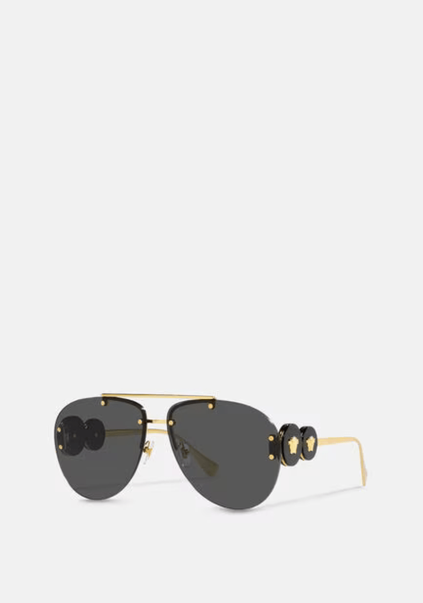 A pair of sunglasses with a gold frame and black lenses on a white background.