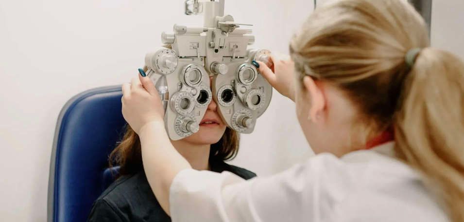 un ophtalmologiste examine l' œil d'un patient avec un appareil .