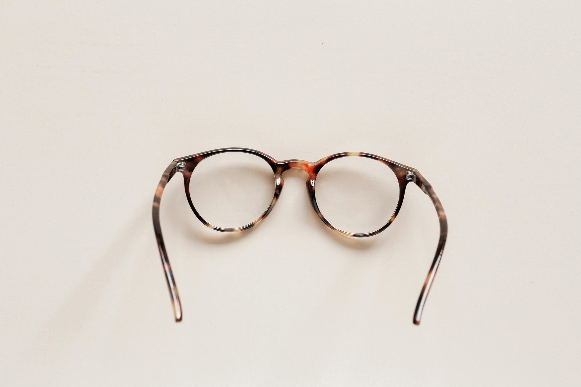 A pair of glasses are sitting on a white surface.