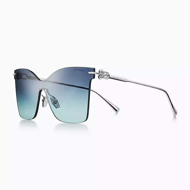 A pair of sunglasses with blue lenses on a white background.