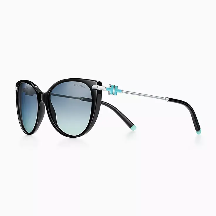 A pair of black sunglasses with blue lenses on a white background.