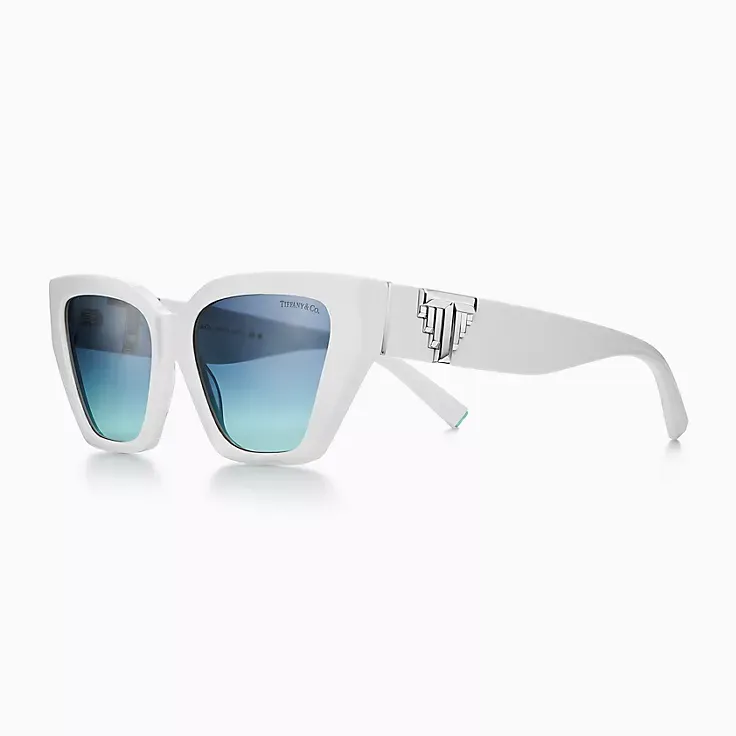 A pair of white sunglasses with blue lenses on a white background.