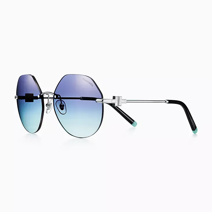 A pair of round sunglasses with blue lenses on a white background.