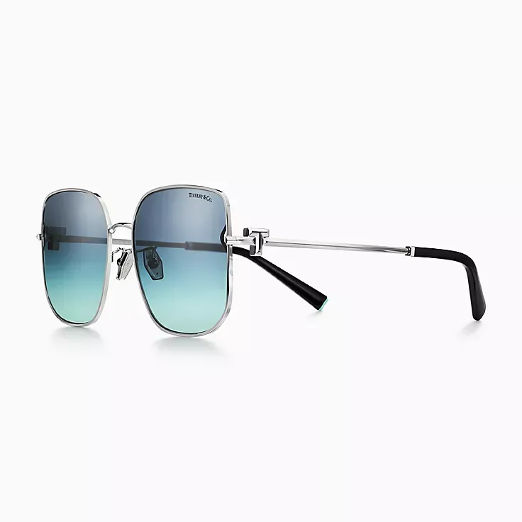 A pair of square sunglasses with blue lenses on a white background.