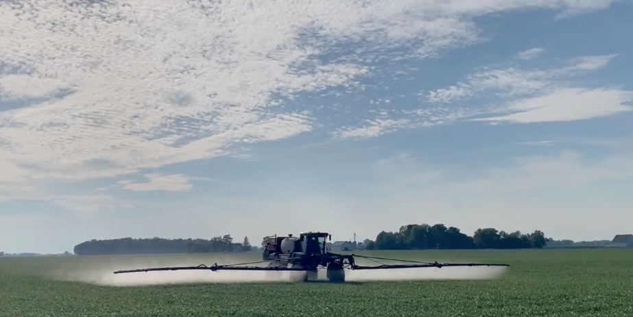 Agricultural sprayer in a field, spraying crops