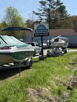 A boat is parked in front of a marina sign.