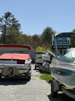 Several boats are parked in front of a marina sign