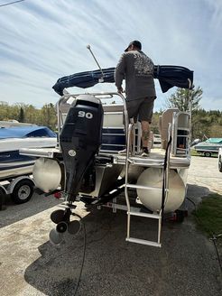 A man is standing on top of a pontoon boat.