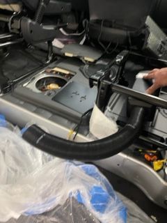 Auto mechanics working underneath a lifted car