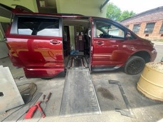Red van with ramp extended for wheelchair access.