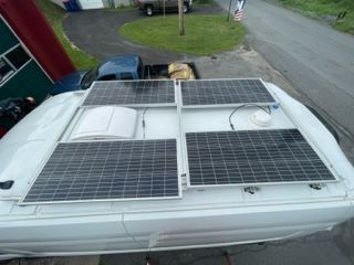 Solar panels mounted on a white van roof.