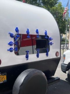 Back of a camper with blue suction cups around a window.