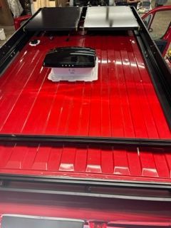 Red truck bed with black accessories installed.