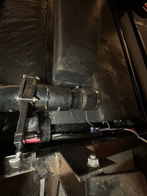 Black RV plumbing components, including a pipe, clamps, and sensors.