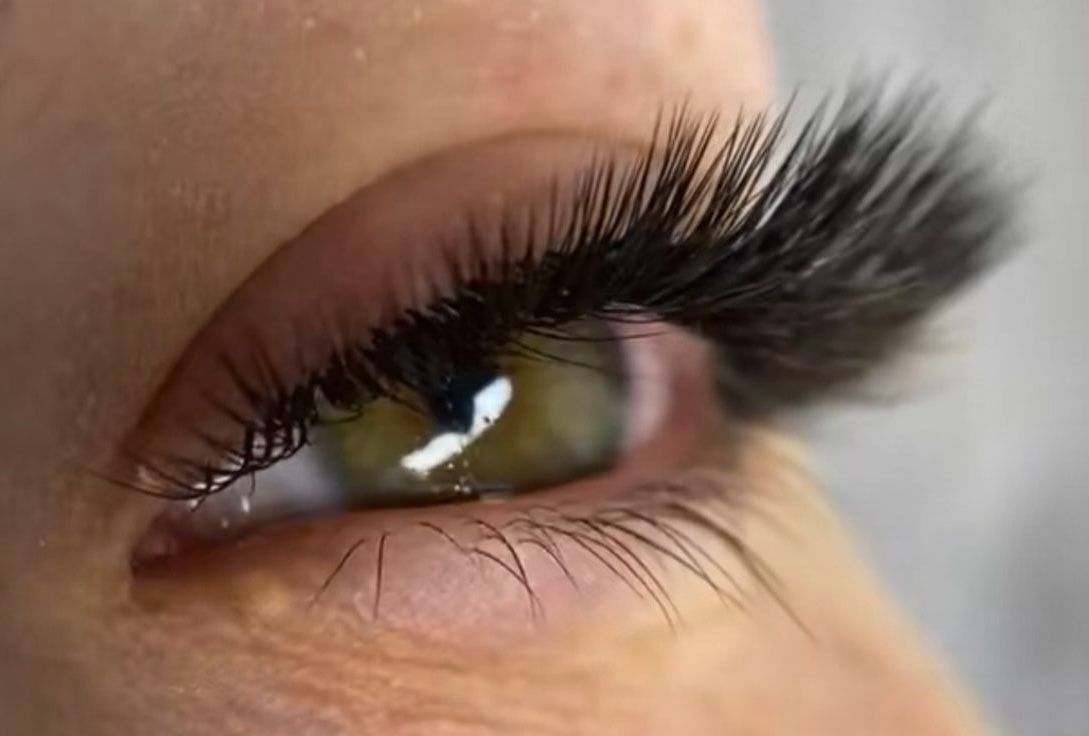 A close up of a woman 's eye with long eyelashes.