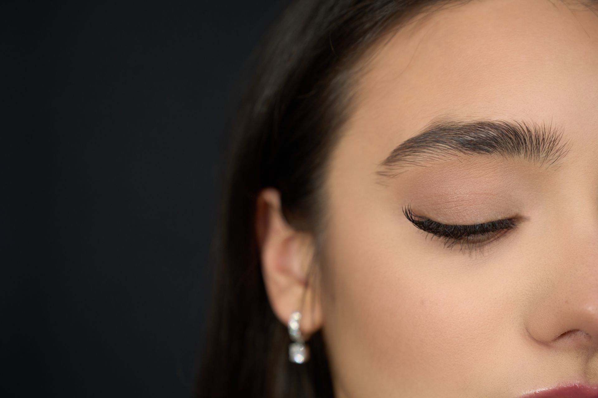 A close up of a woman 's face with her eyes closed.