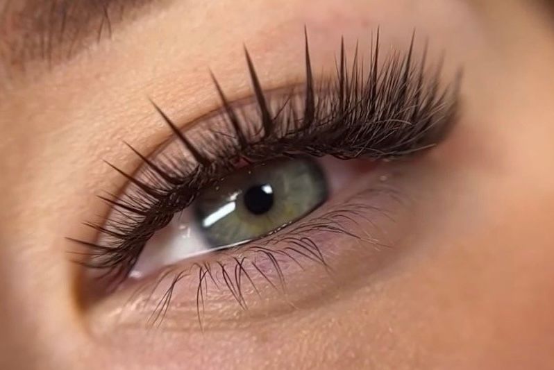 A close up of a woman 's eye with long eyelashes.