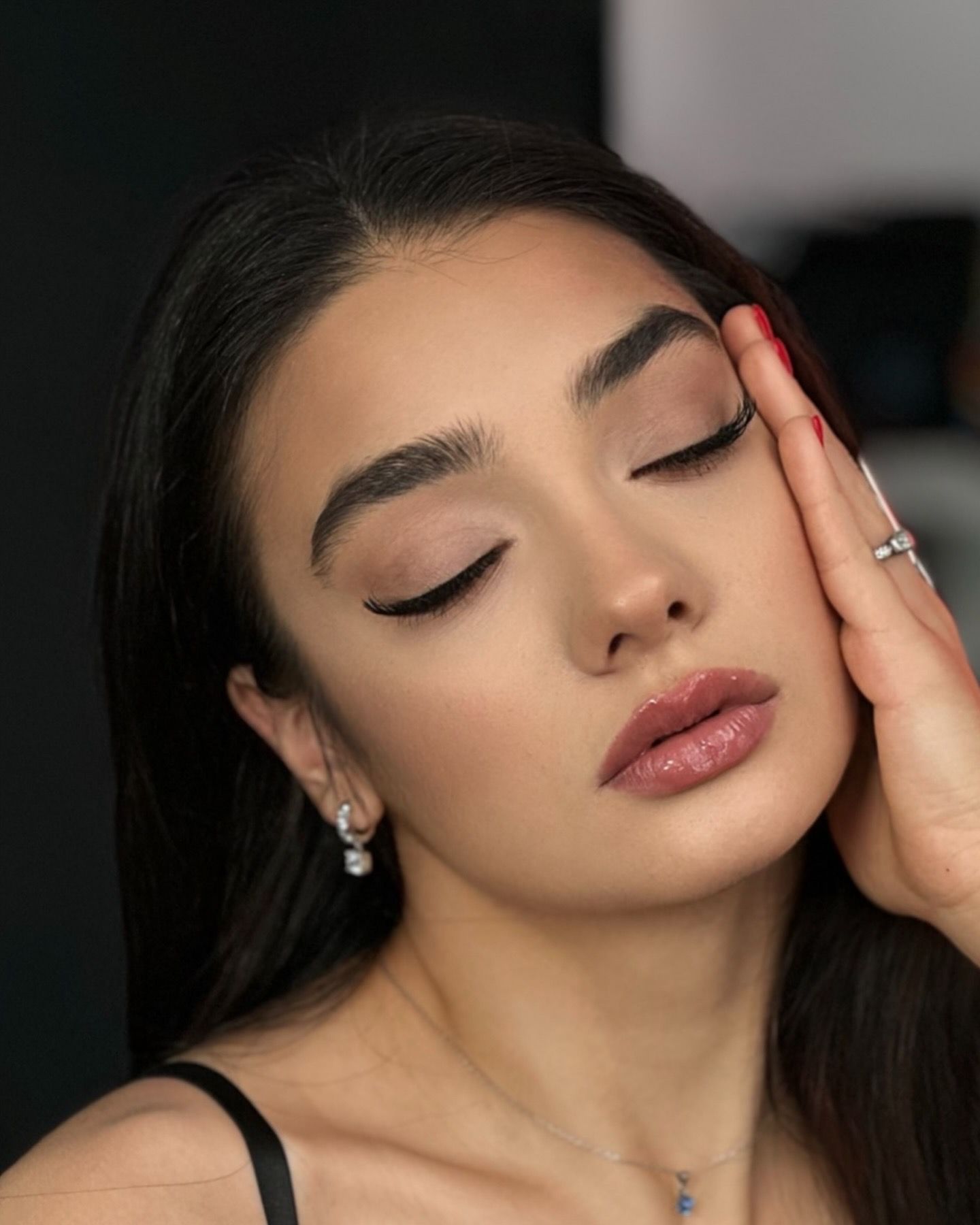 A close up of a woman 's face with her eyes closed