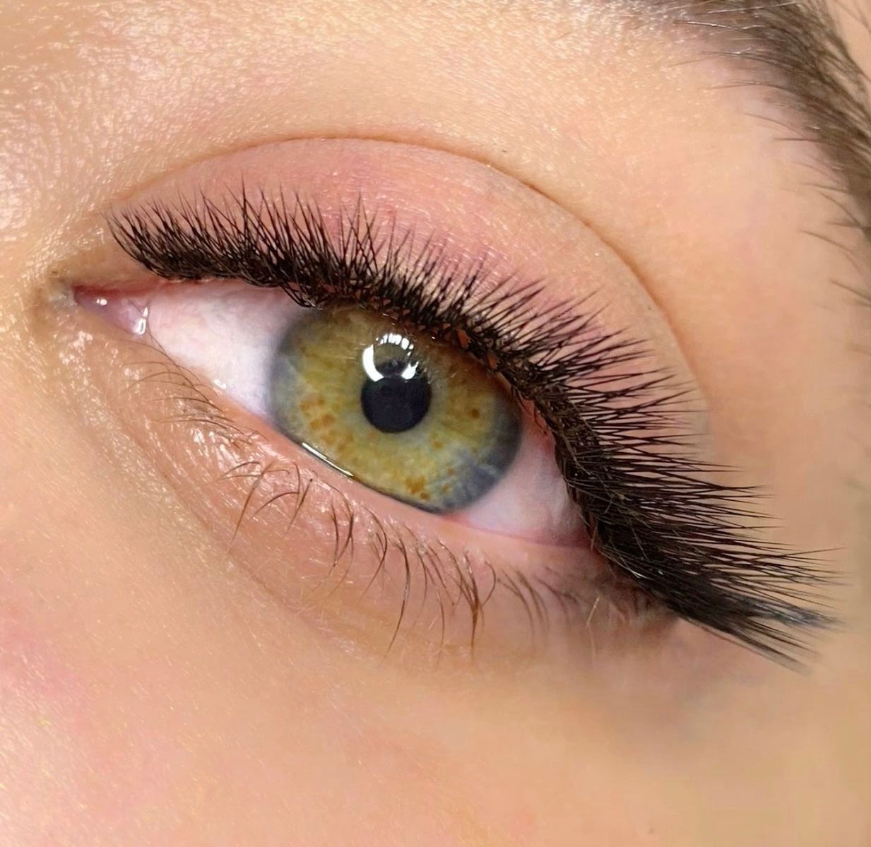 A close up of a woman 's eye with long eyelashes.