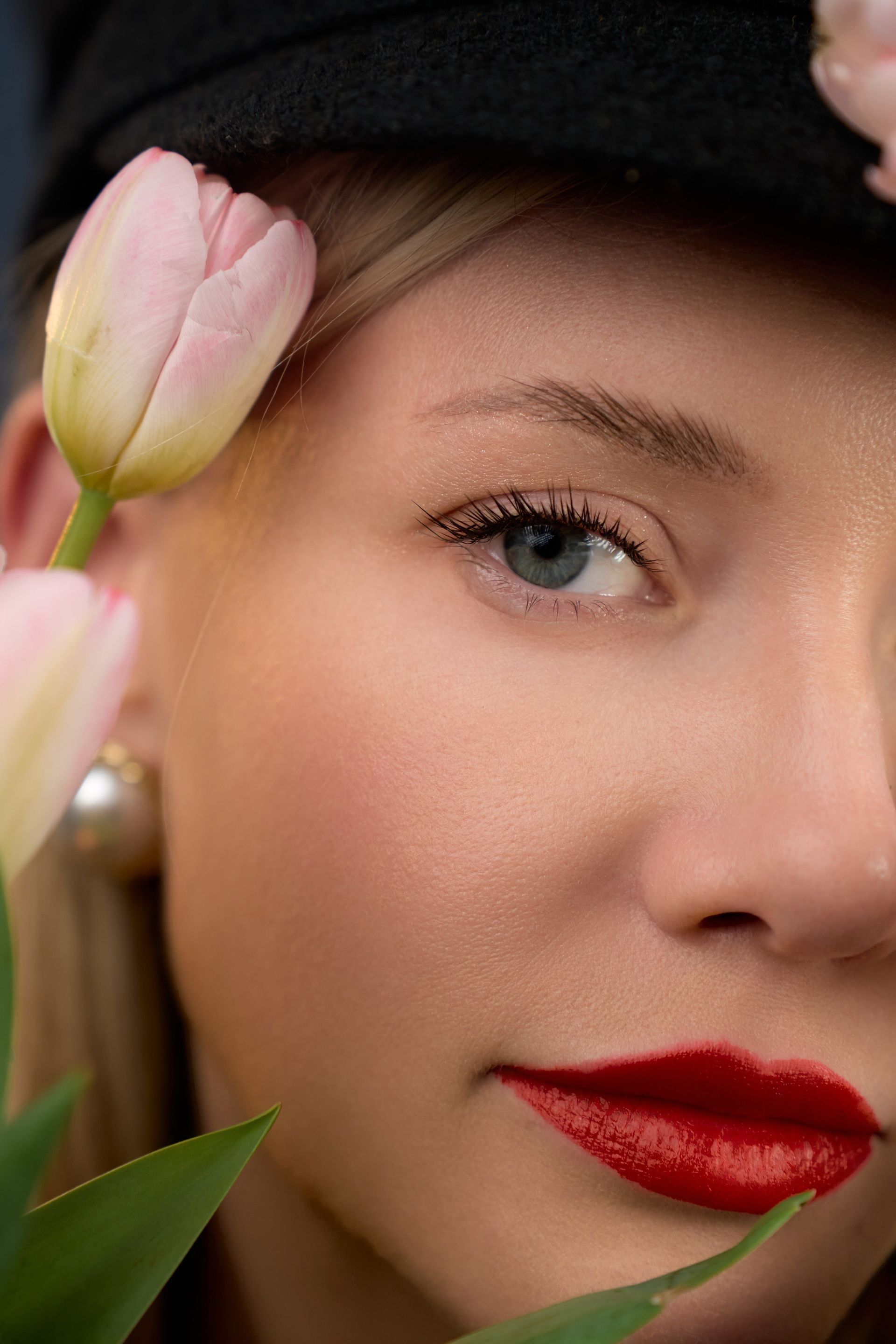 A close up of a woman 's face with a flower in her ear.