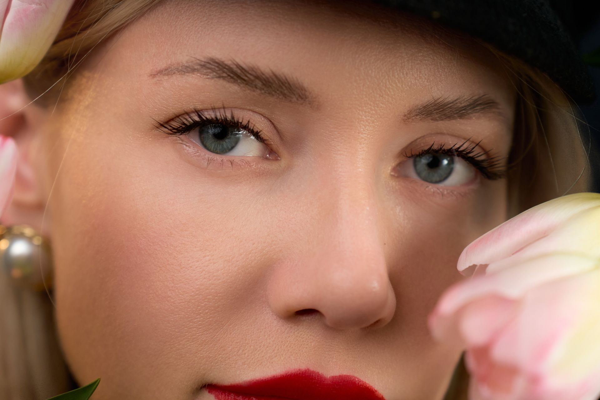 A close up of a woman 's face with a flower in her hand.