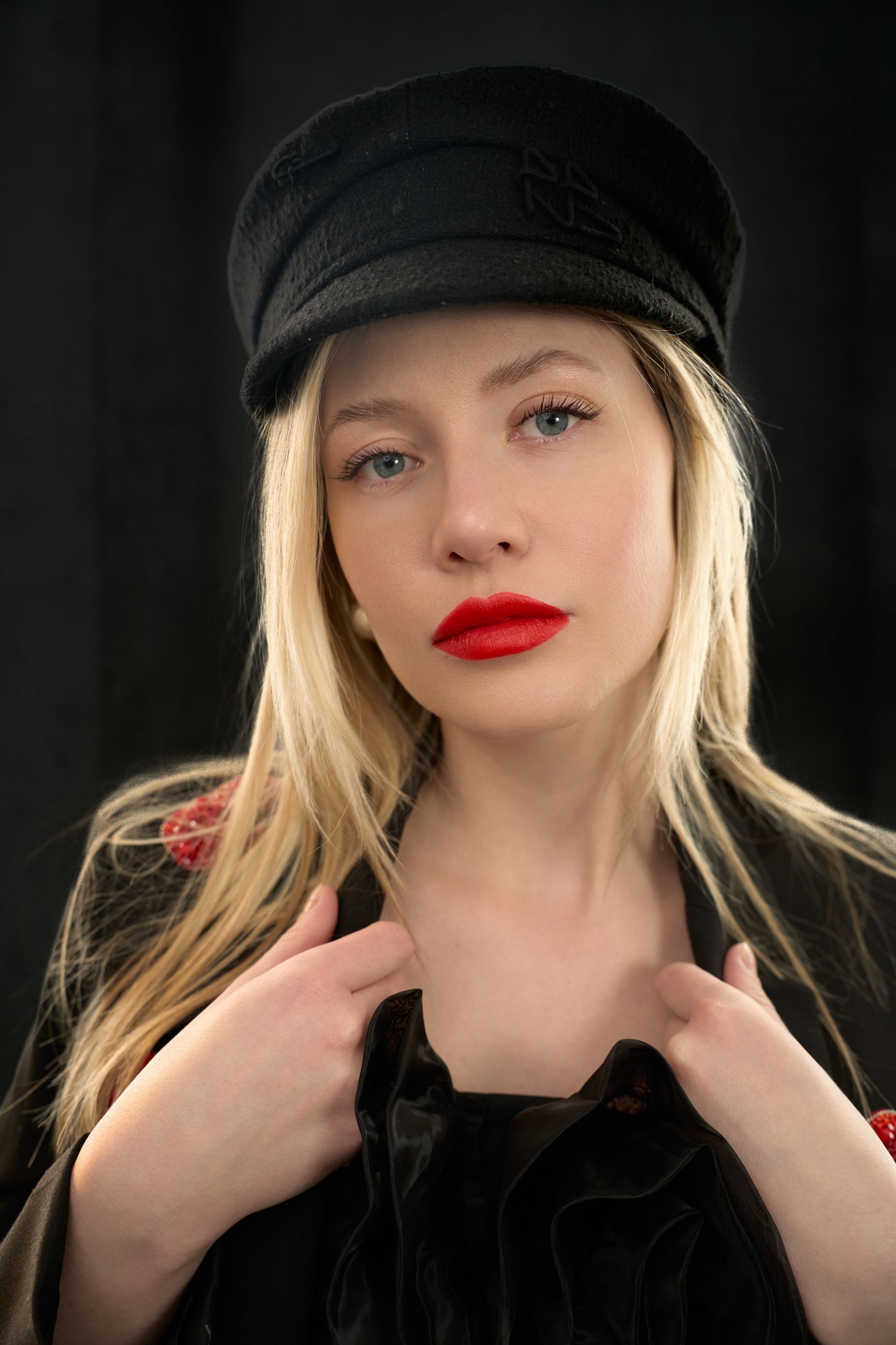 a woman with red lipstick on and wet effect lashes