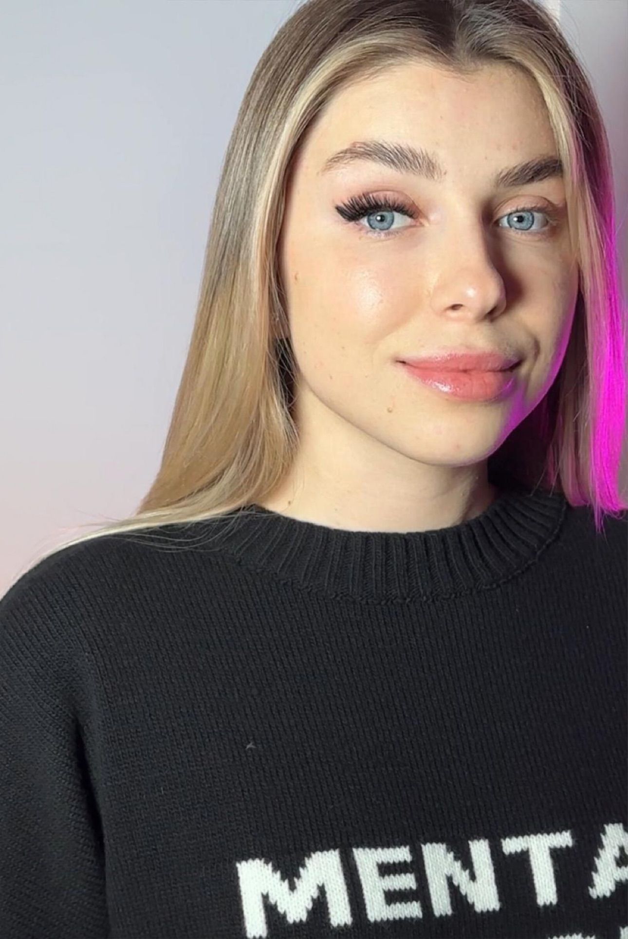 A woman wearing a black sweater with the word menta on it.