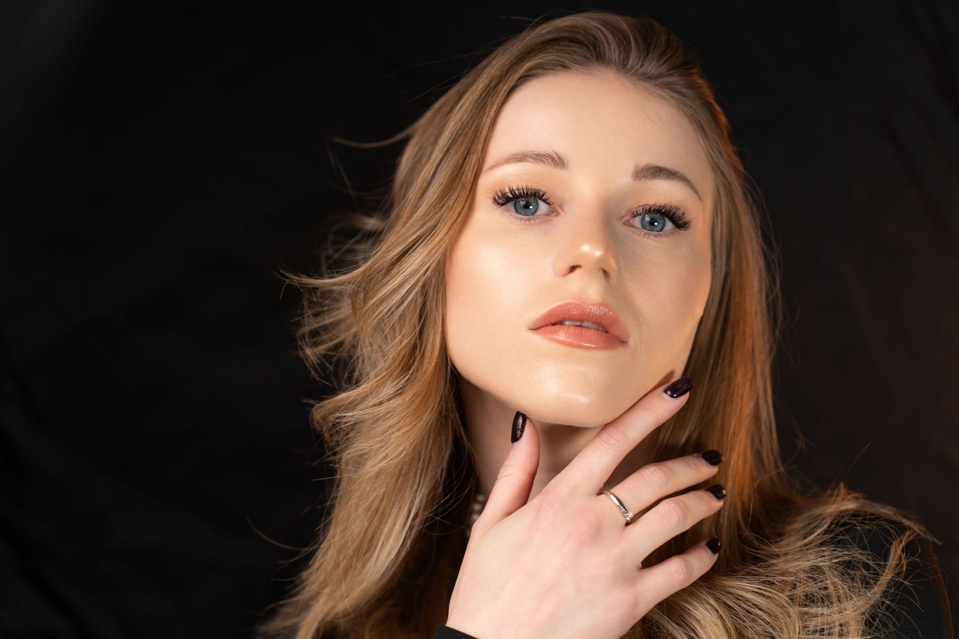 A close up of a woman 's face with her hand on her chin.