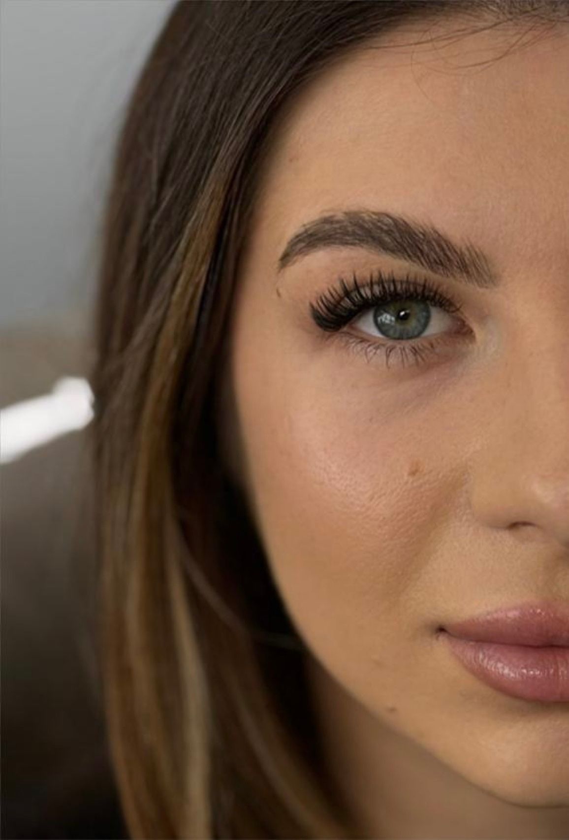 A close up of a woman 's face with false eyelashes.