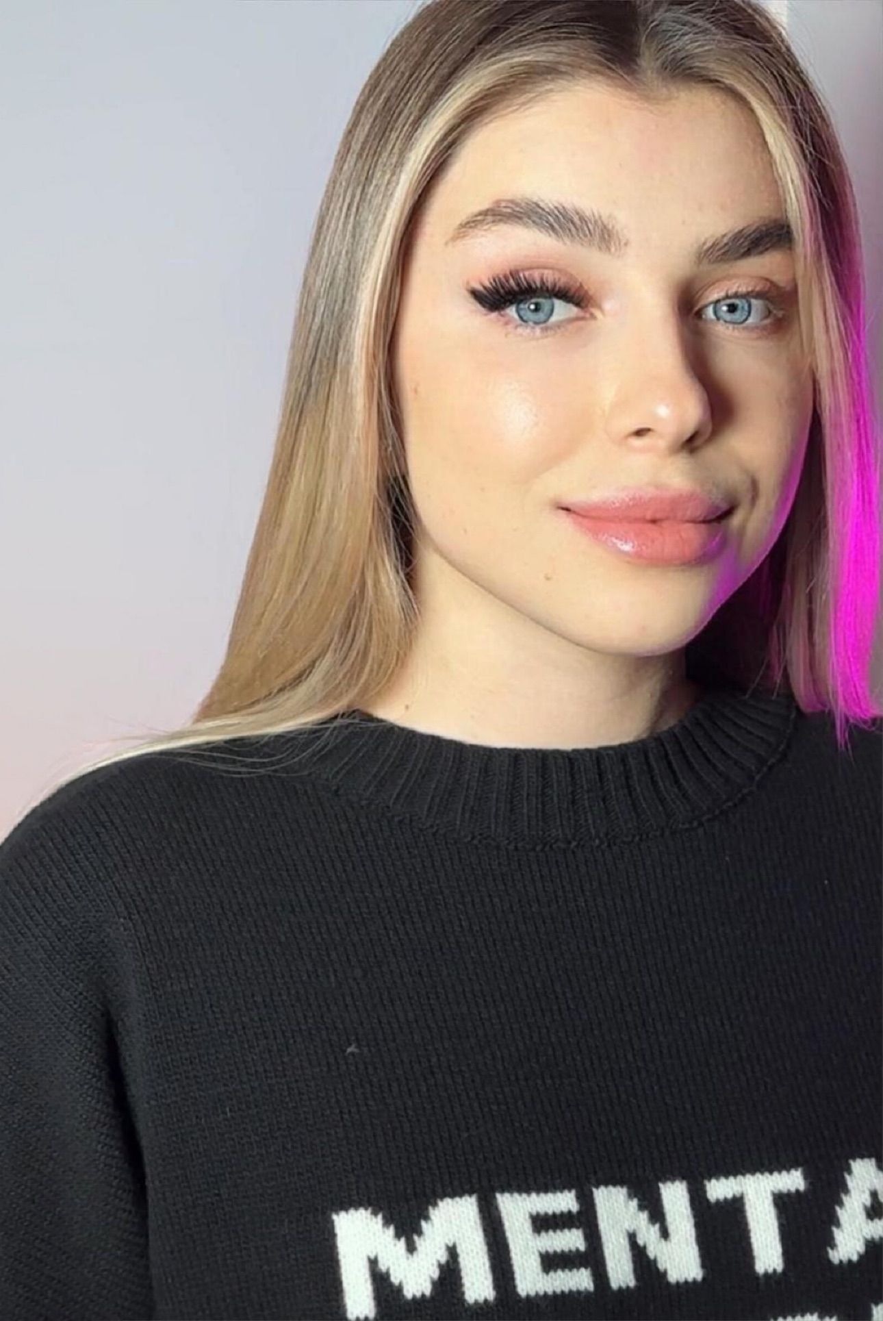 A woman wearing a black sweater with the word menta on it