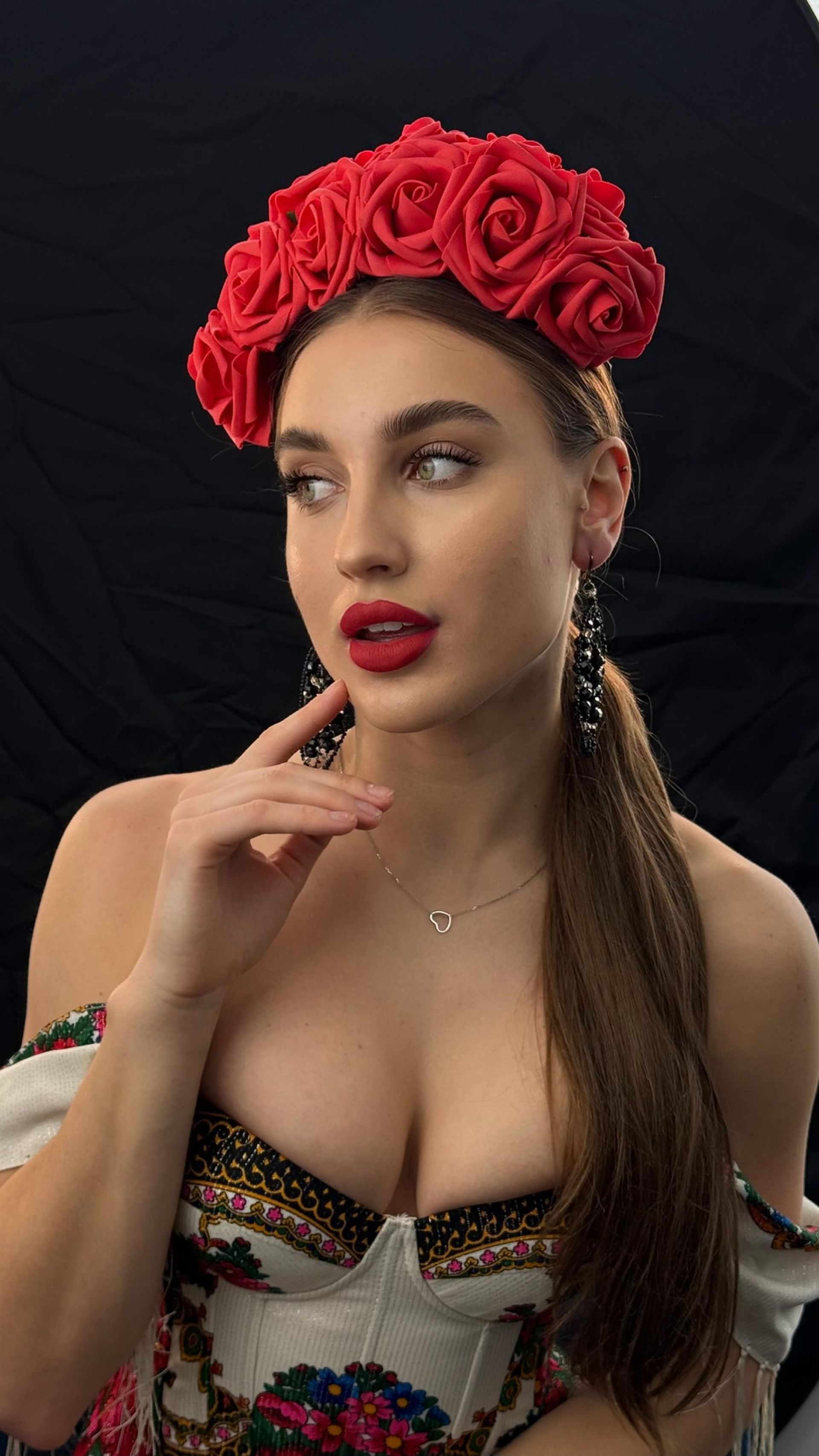 A woman is wearing a red flower crown on her head.