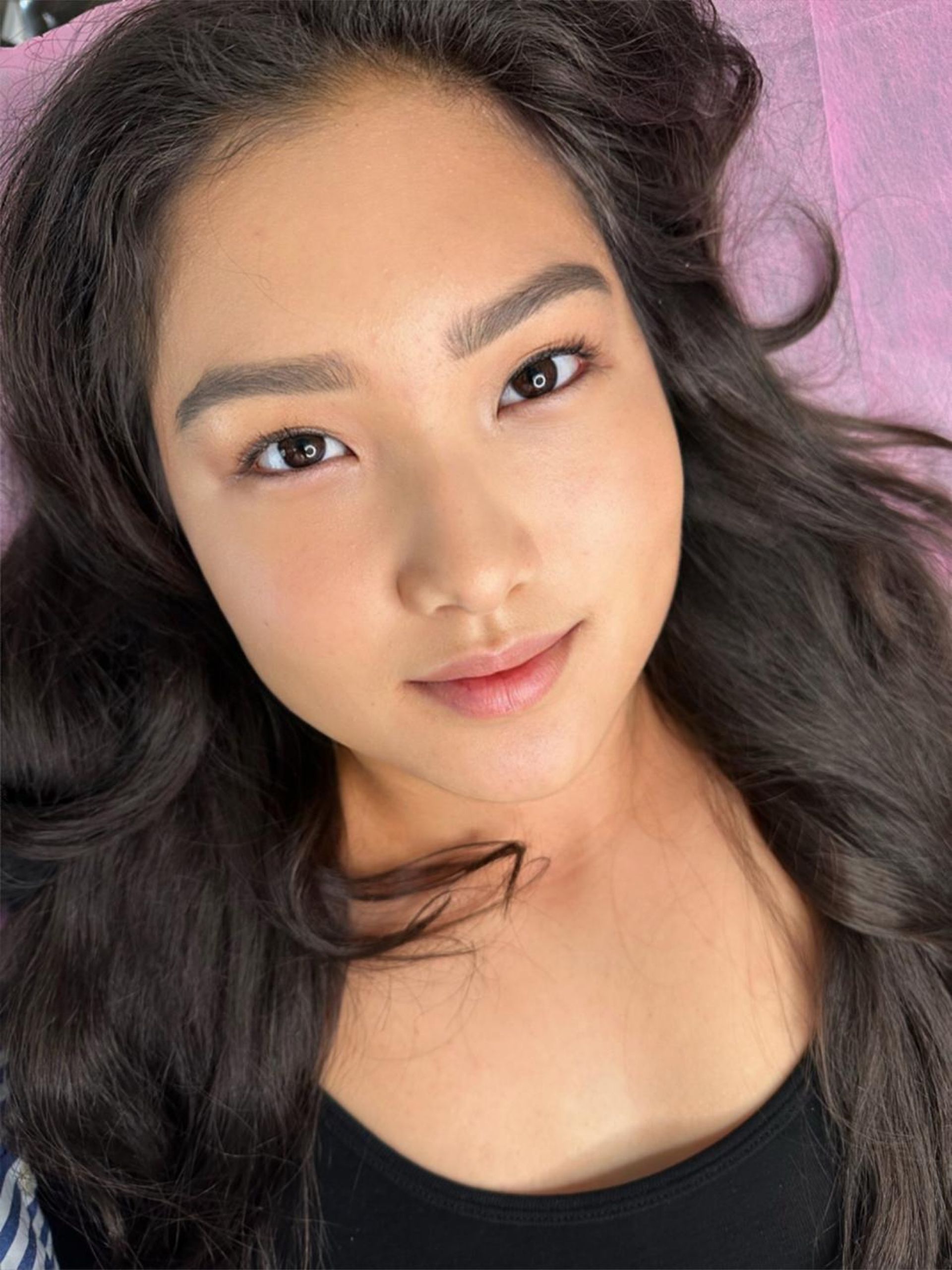 A close up of a woman 's face with long hair and a black shirt.