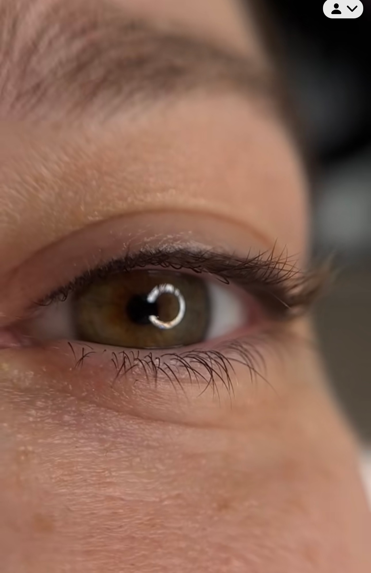 A close up of a woman 's eye with long eyelashes.