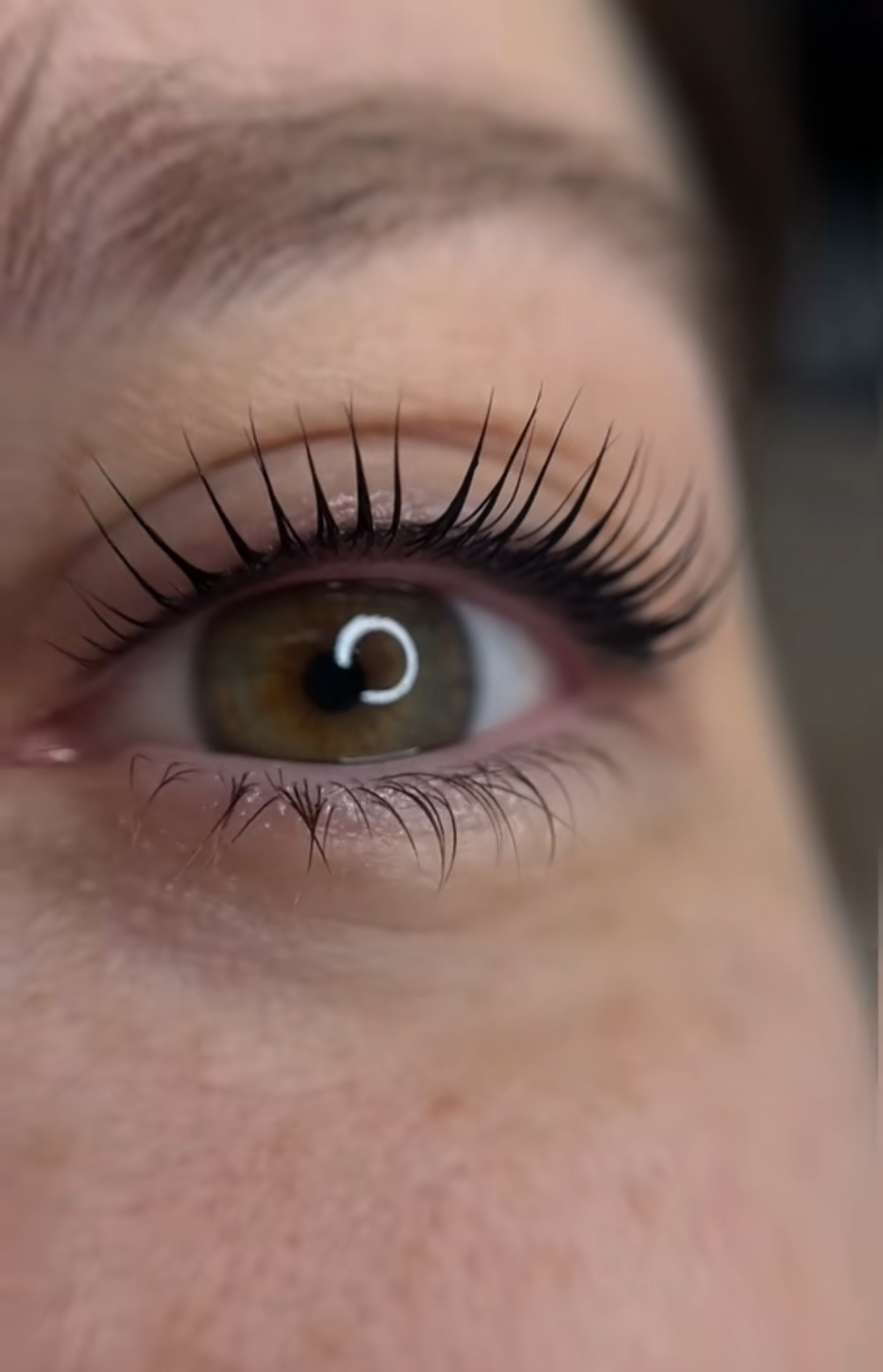 A close up of a woman 's eye with long eyelashes.