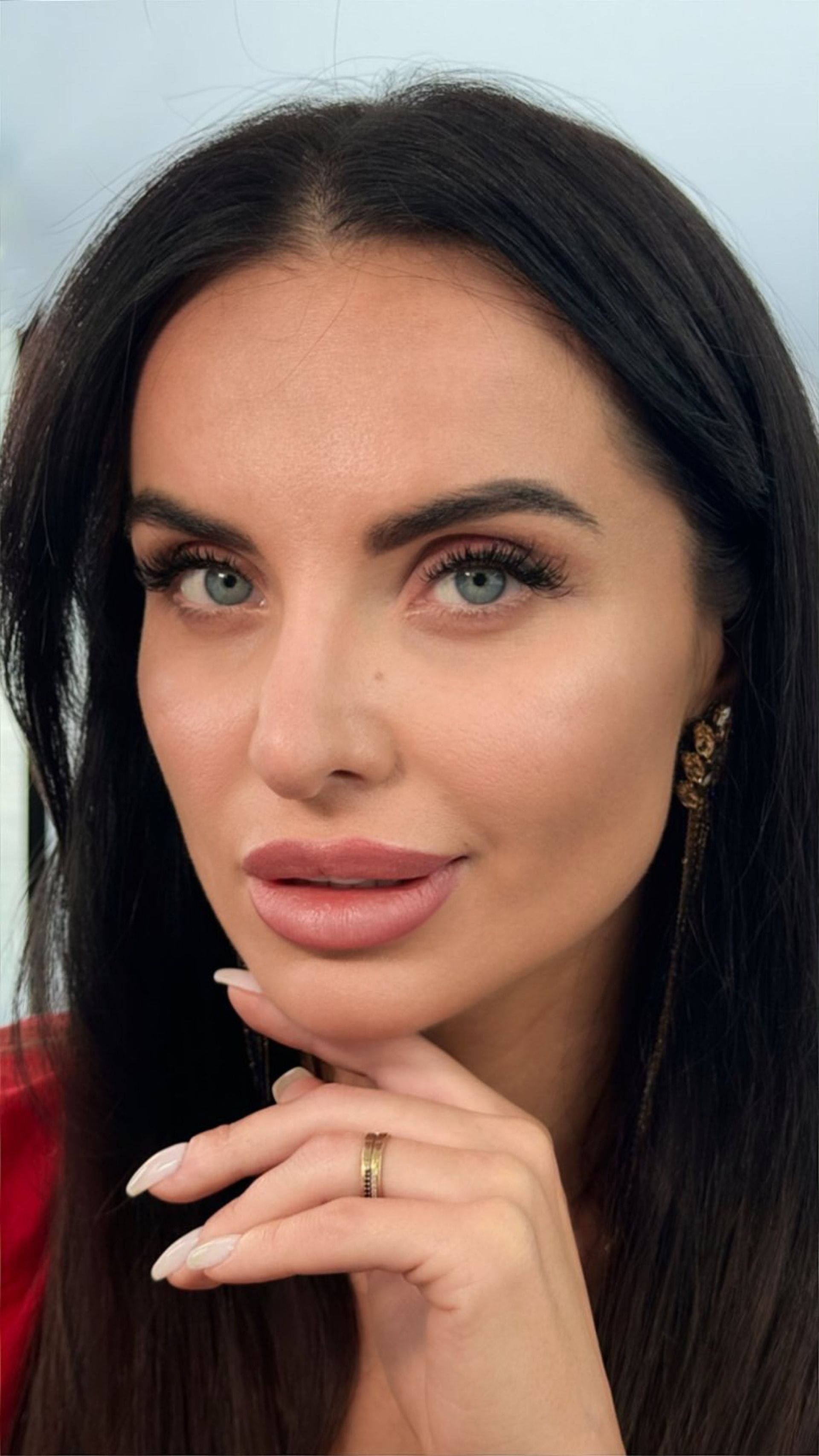 A close up of a woman 's face with her hand on her chin.