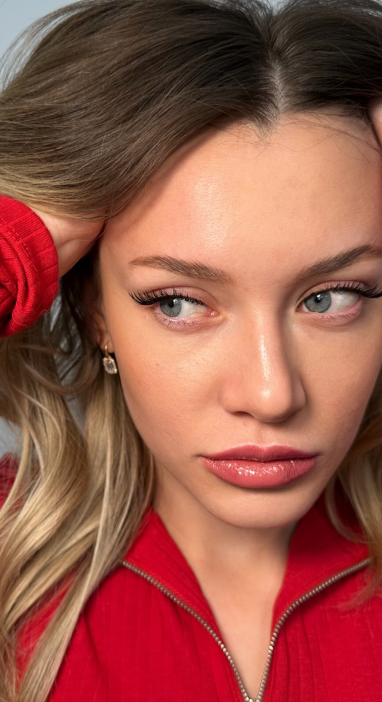 A close up of a woman 's face wearing a red jacket.