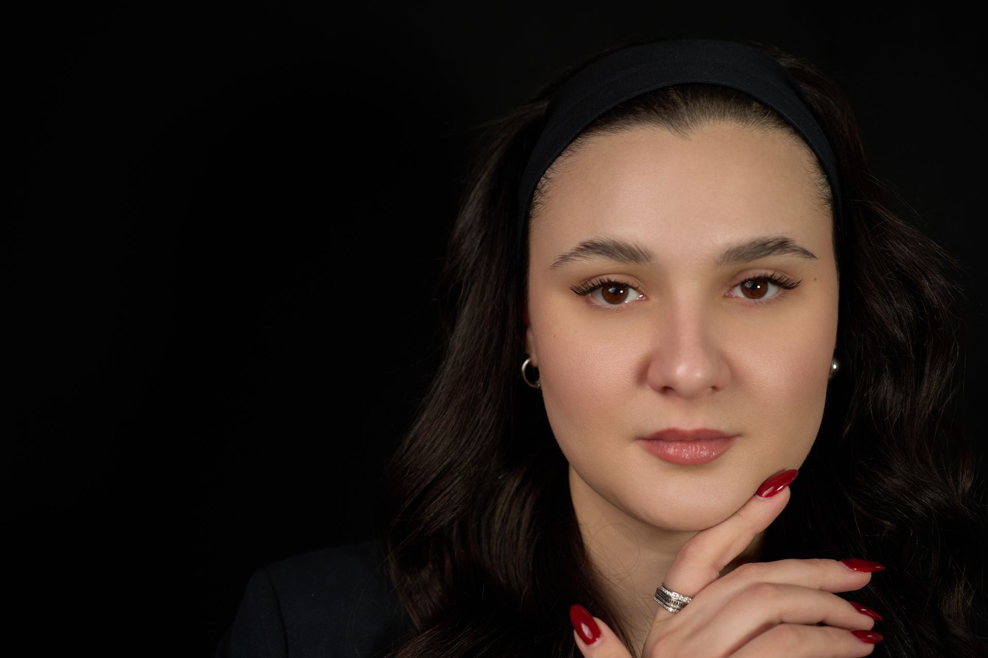 A close up of a woman 's face with her hand on her chin.